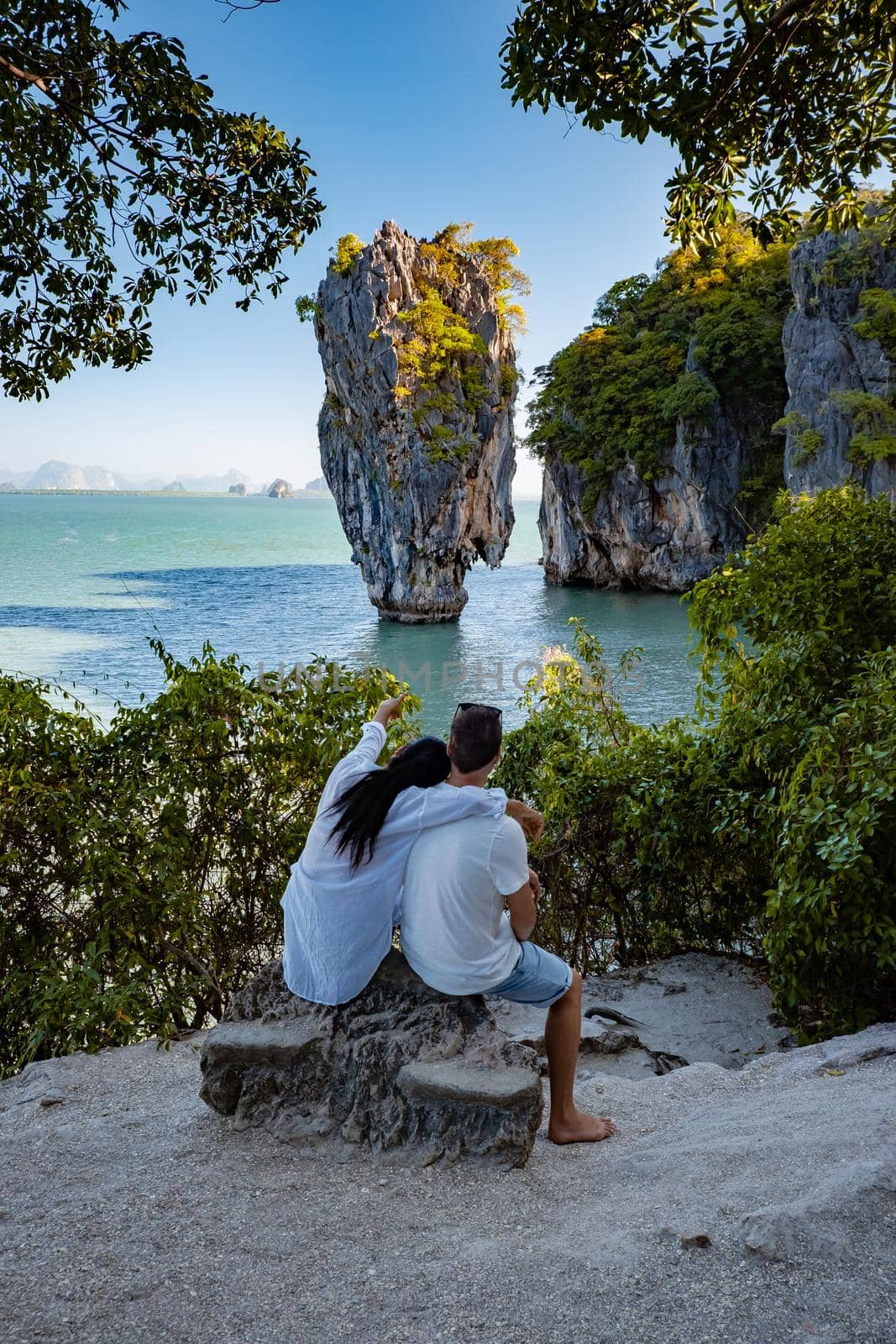 James Bond island near Phuket in Thailand. Famous landmark and famous travel destination, couple men and woman mid age visiting James Bond island in Krabi Thailand. European man and Asian woman on vacation