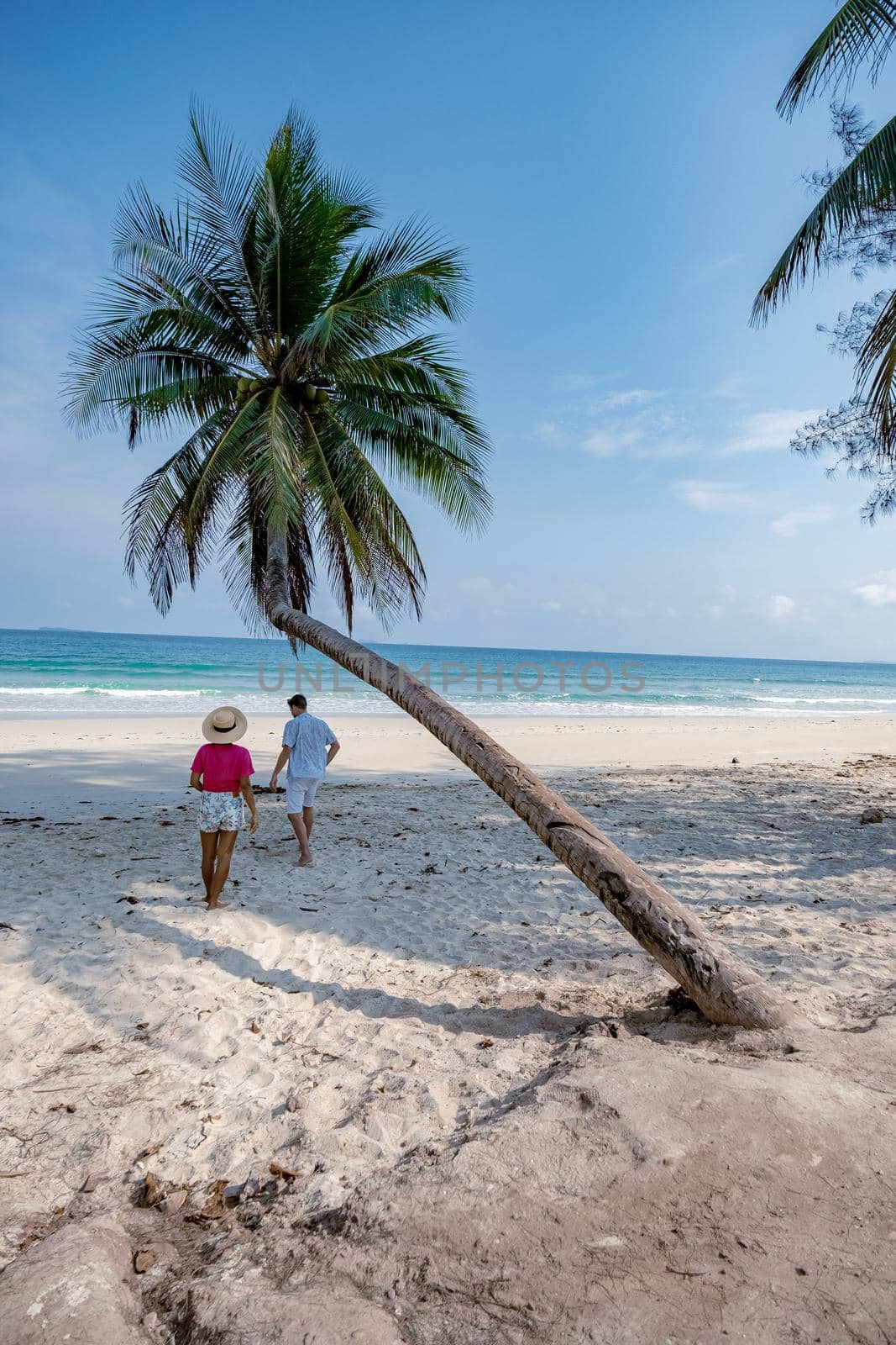 couple on vacation in Thailand, Chumpon province , white tropical beach with palm trees, Wua Laen beach Chumphon area Thailand, palm tree hanging over the beach with couple on vacation in Thailand by fokkebok