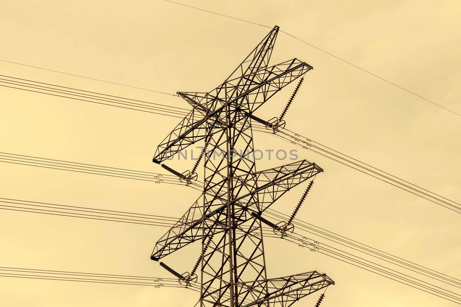 Close up view of the upper section of a steel electrical Transmission Tower and the associated transmission cables and connectors