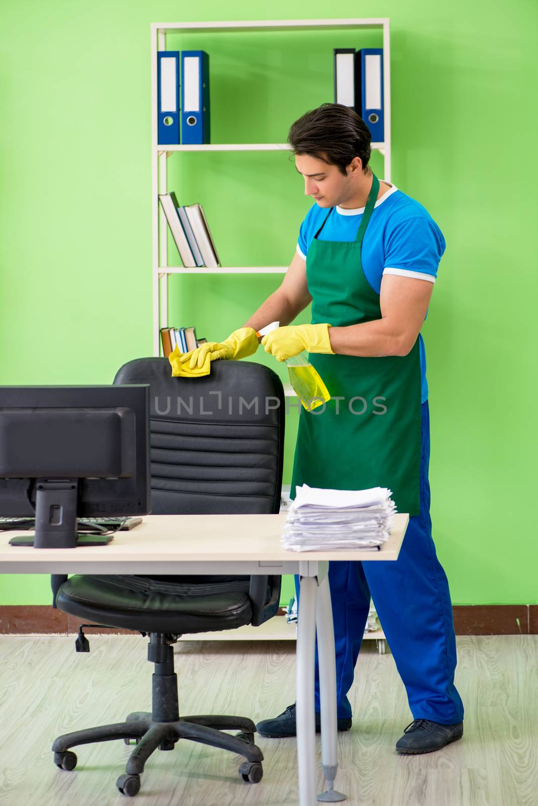 Male handsome professional cleaner working in the office