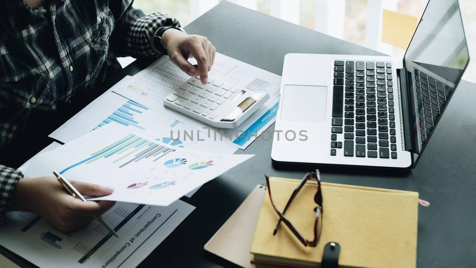Close up Businessman using calculator and laptop for calaulating finance, tax, accounting, statistics and analytic research concept