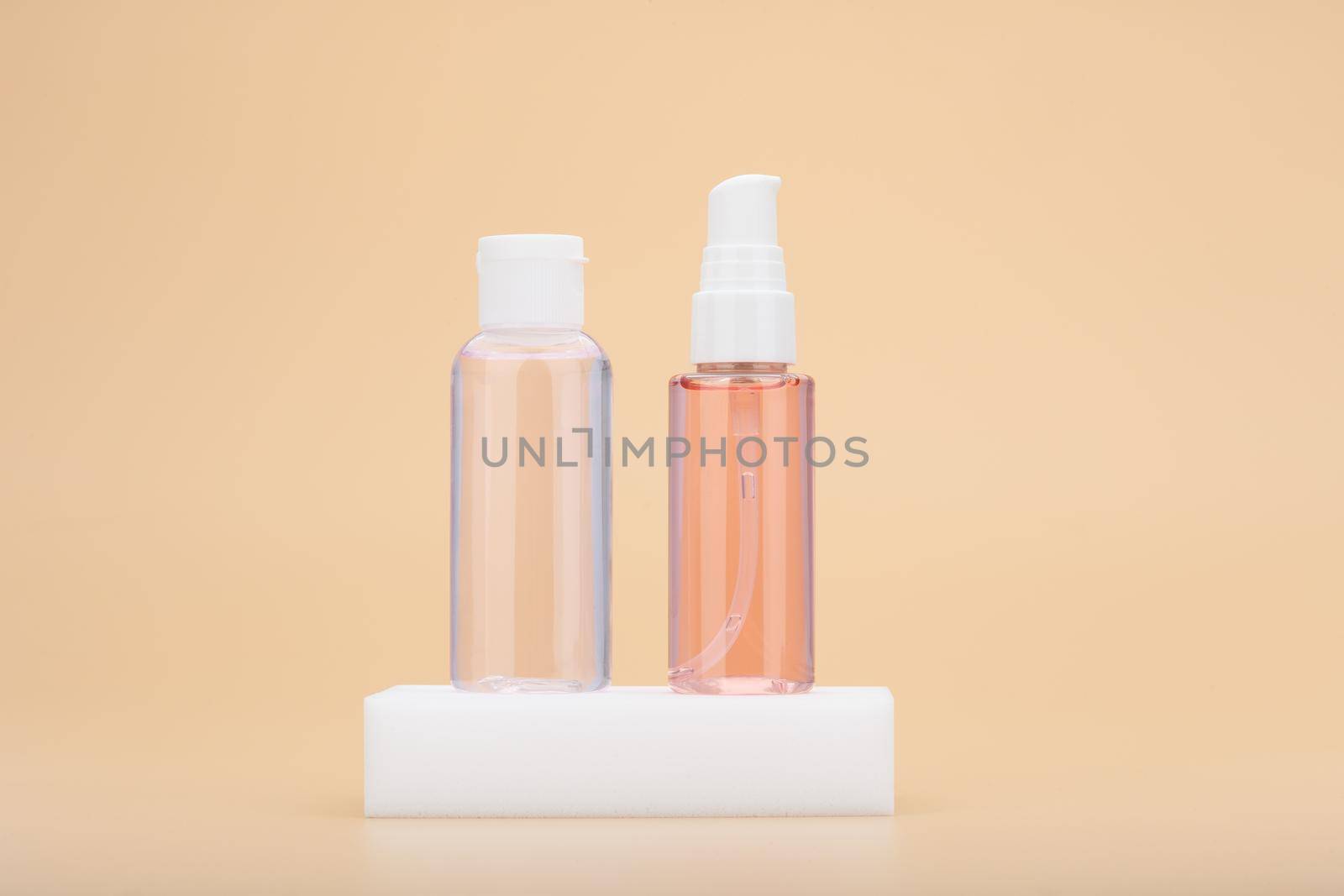 Skin hydrating lotion and cleansing foam or gel on white podium against beige background. Beauty products for skin treatment at home. Concept of clean and smooth skin