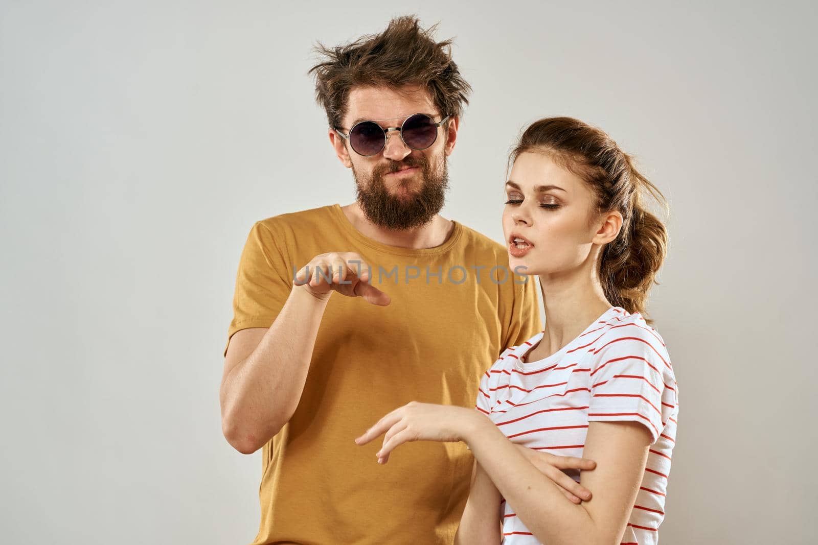 man in sunglasses next to woman in striped t-shirt emotions communication fashion studio fun by SHOTPRIME