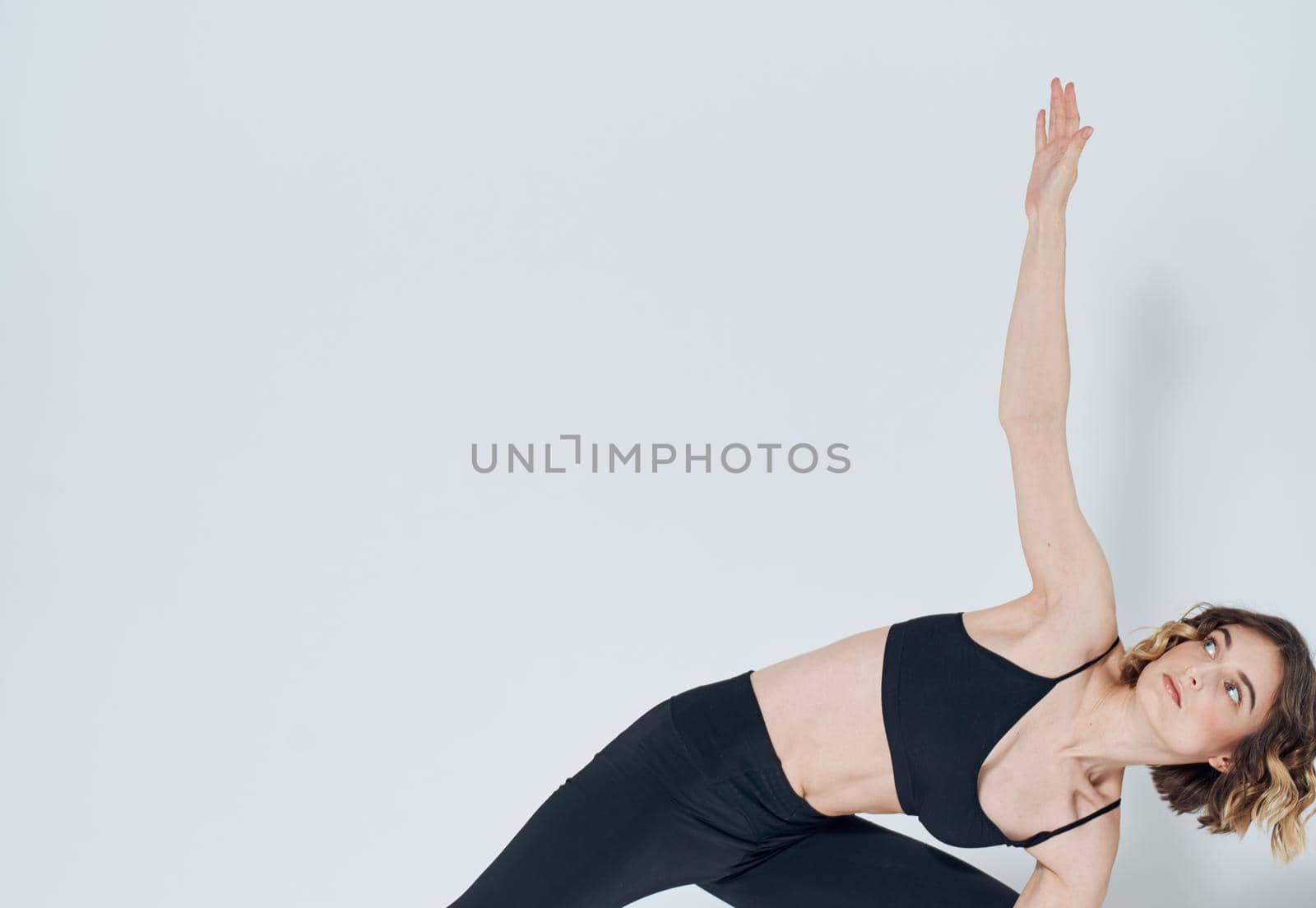 sportive woman doing exercises bending knees yoga asana by SHOTPRIME