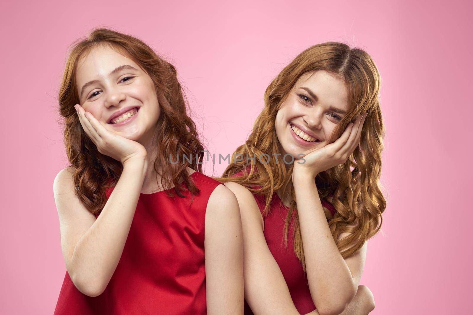 Mom and daughter fun communication family joy pink background cropped view. High quality photo
