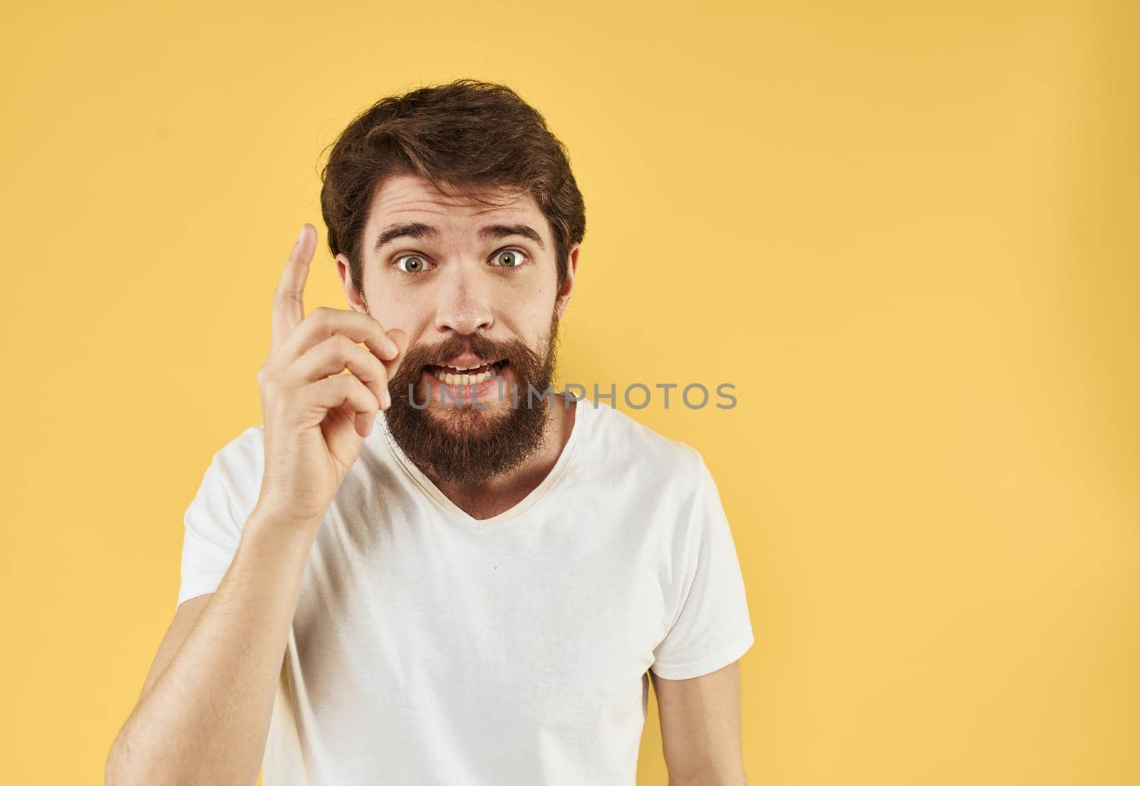 A man gesturing with his hands on a yellow background Copy Space cropped view. High quality photo