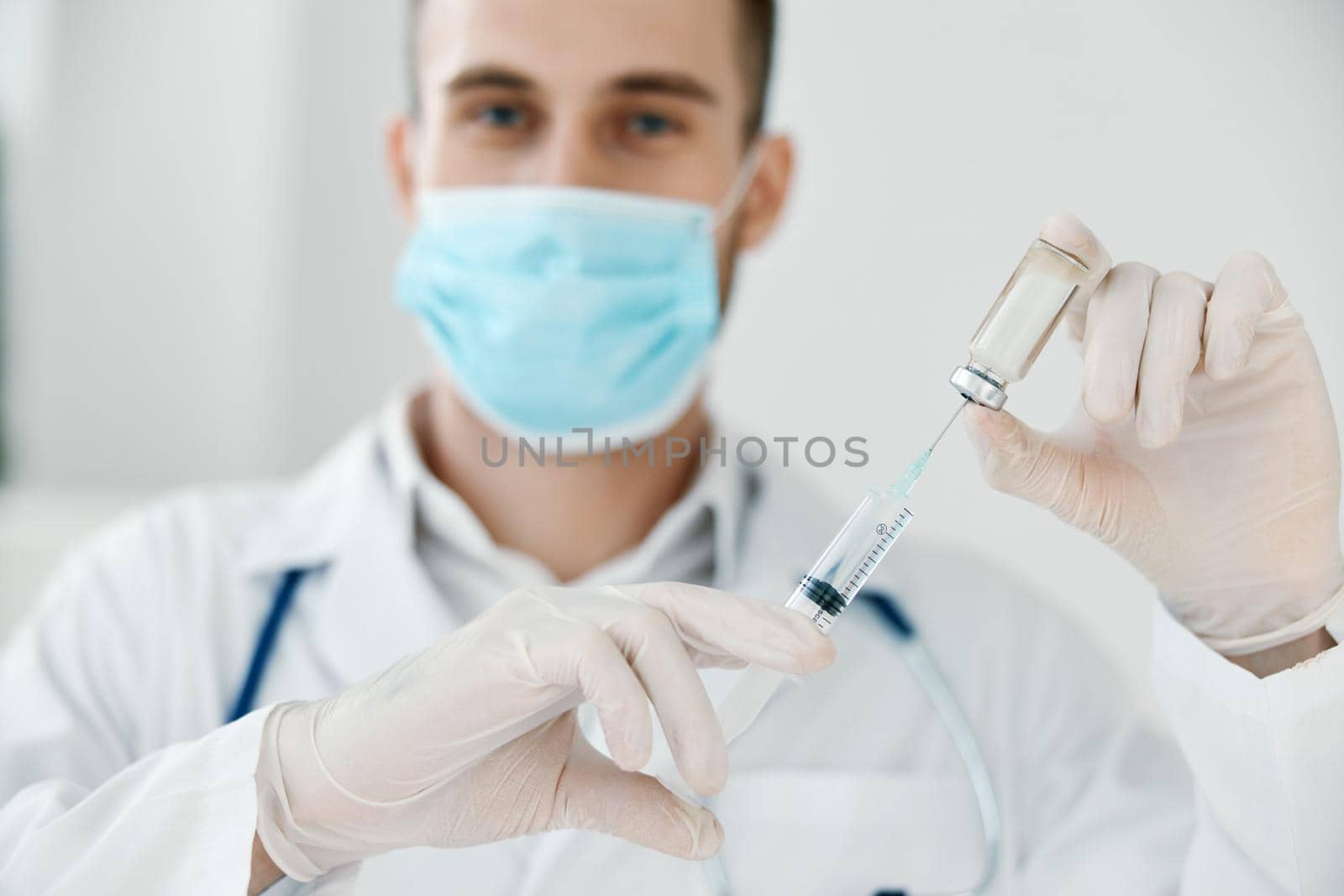 doctor with syringe in hand coronavirus vaccine medical gown face mask. High quality photo