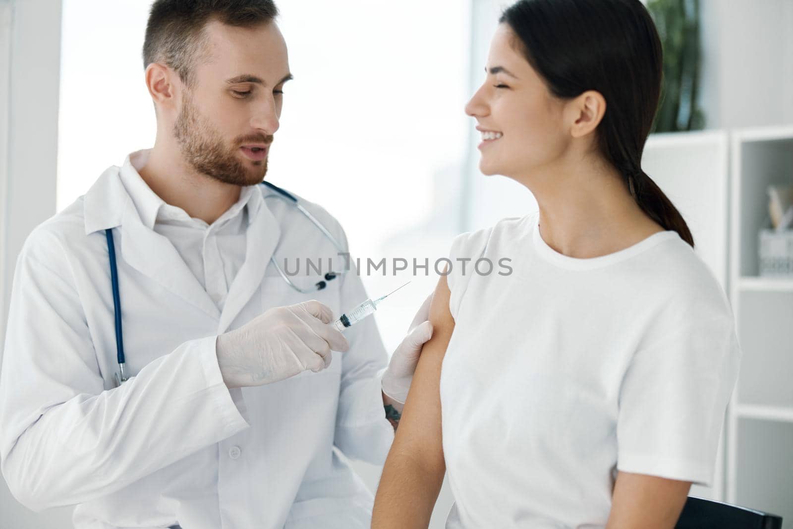 doctor in protective gloves injects a woman's shoulder from covid-19 vaccination. High quality photo