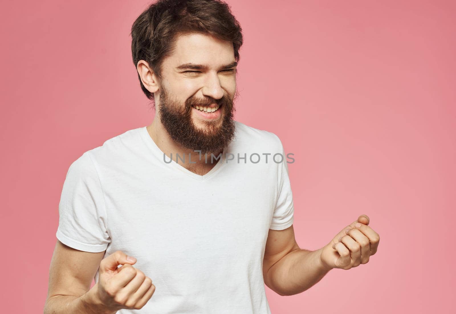 emotional man on pink background gesturing with his hands fun. High quality photo