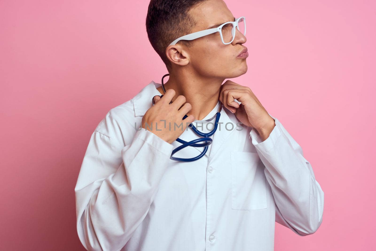Male doctor white coat medicine treatment pink background hospital. High quality photo