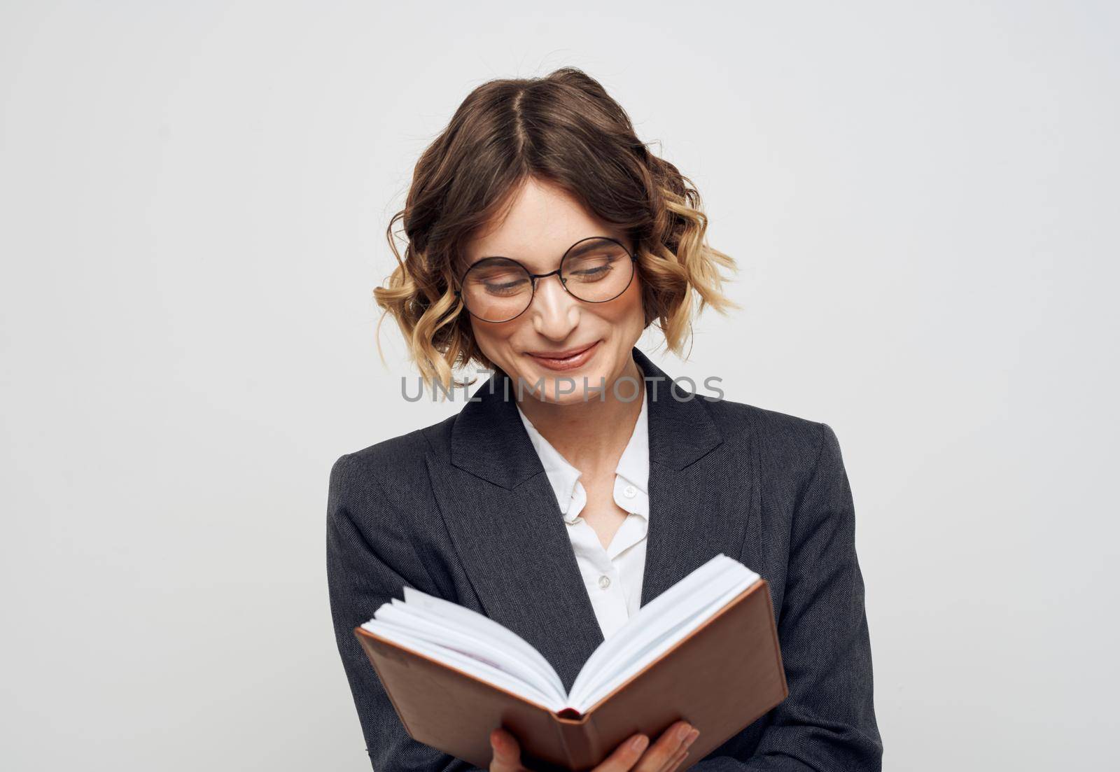 Woman in classic suit with open book glasses on face cropped view by SHOTPRIME