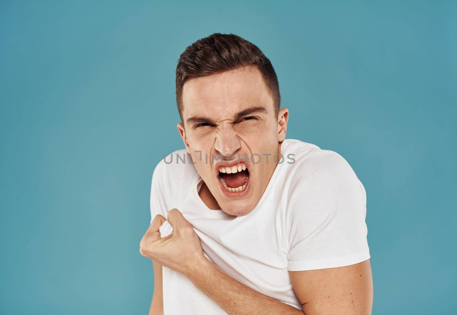 man in white t-shirt emotions model blue background. High quality photo
