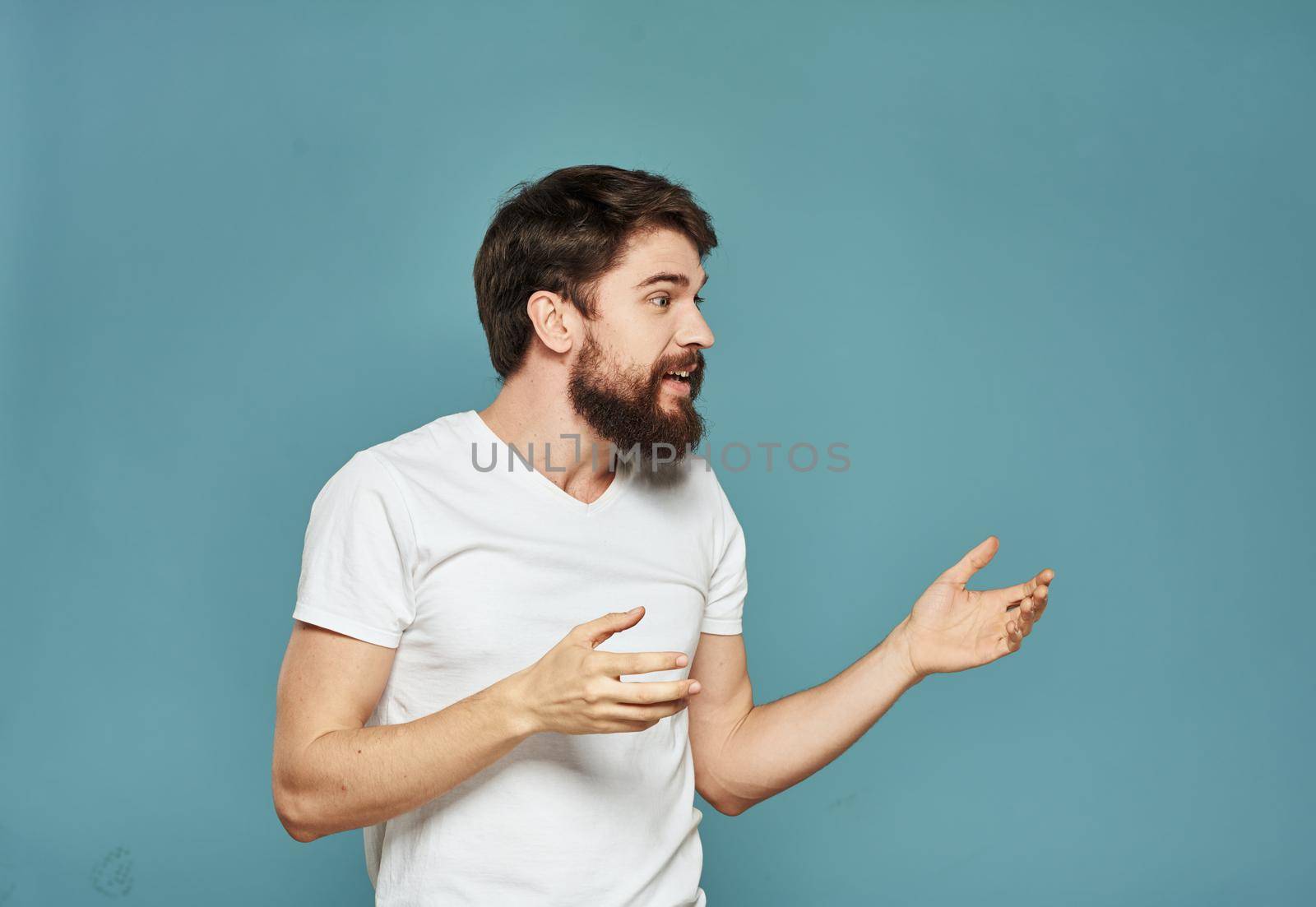 Energetic man gesturing with his hands on a blue background joy emotion delight model. High quality photo