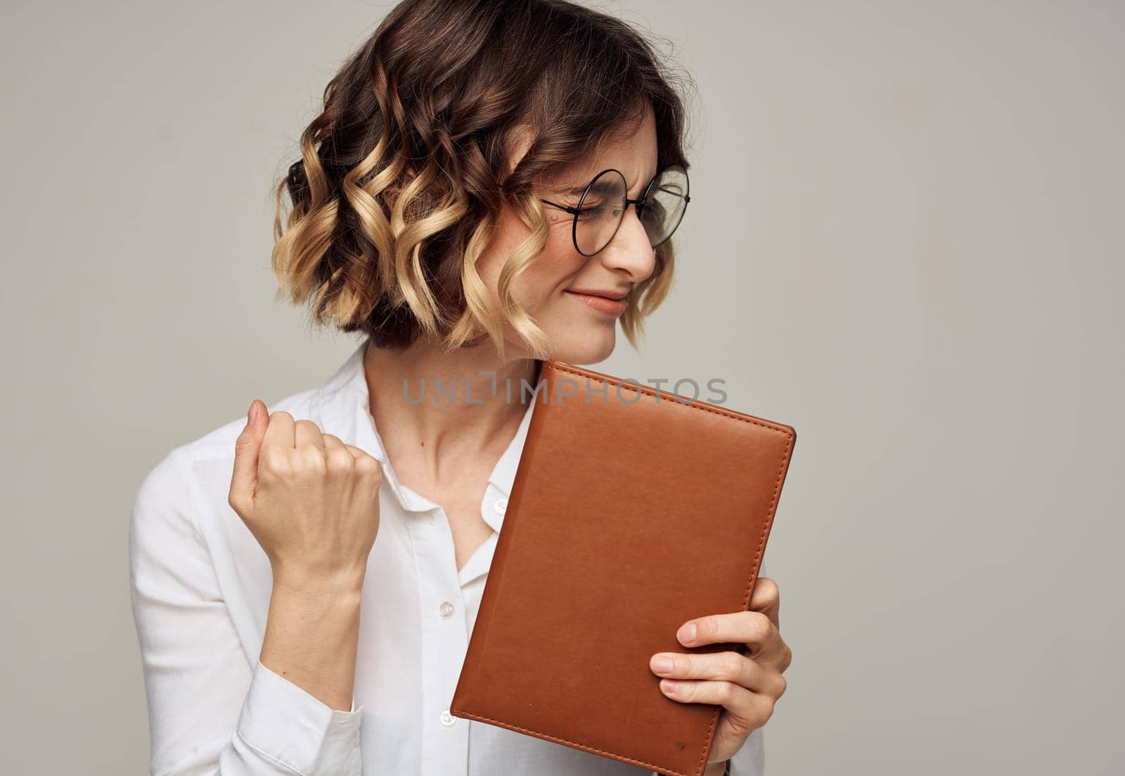 Business woman short hair white shirt and notepad in hand. High quality photo