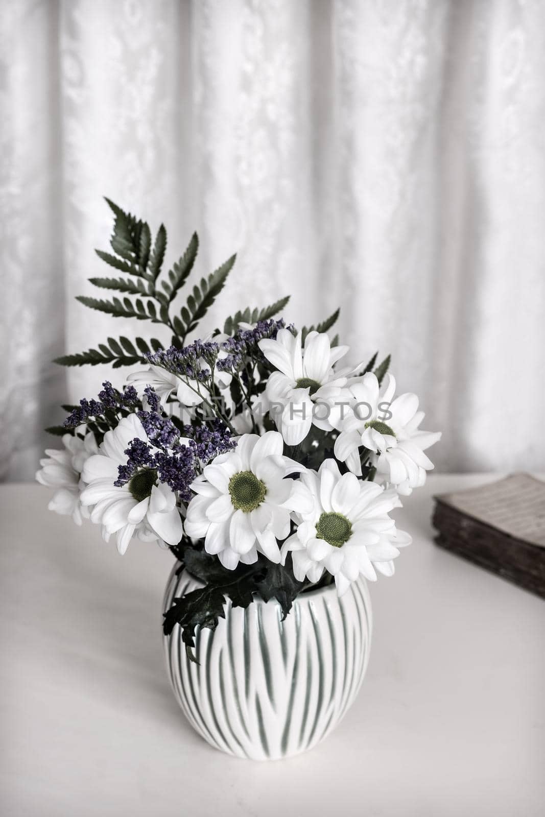 White chrysanthemums on the table in a ceramic vase by georgina198