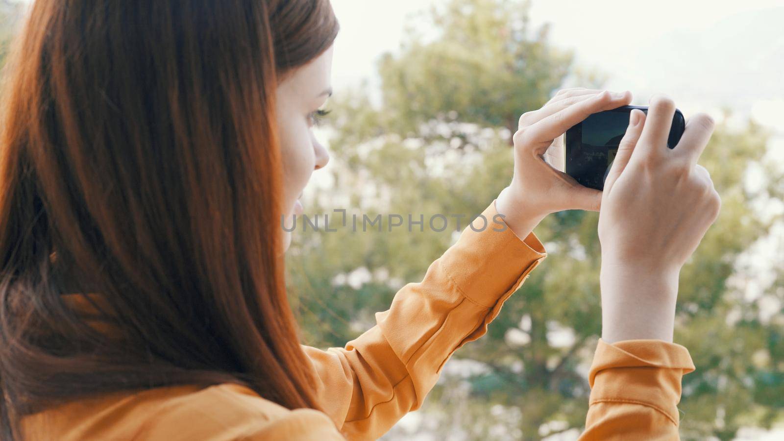 woman outdoors with a phone in her hands taking pictures of nature panorama rest by SHOTPRIME