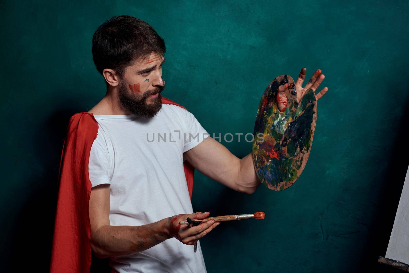 A man in a white T-shirt red cloak drawing art Green background. High quality photo