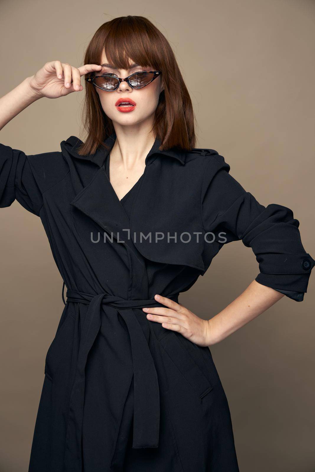 Sexy woman touches face with his hand dark glasses beige isolated background