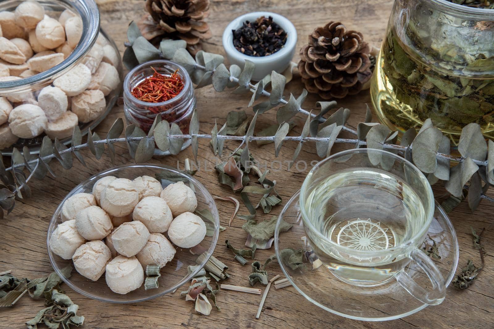 Morning refreshing with herbal tea which is served with Khanom Ping (Thai traditional dessert). The desserts is served on rustic wooden background. Thai style high tea, Selective focus.