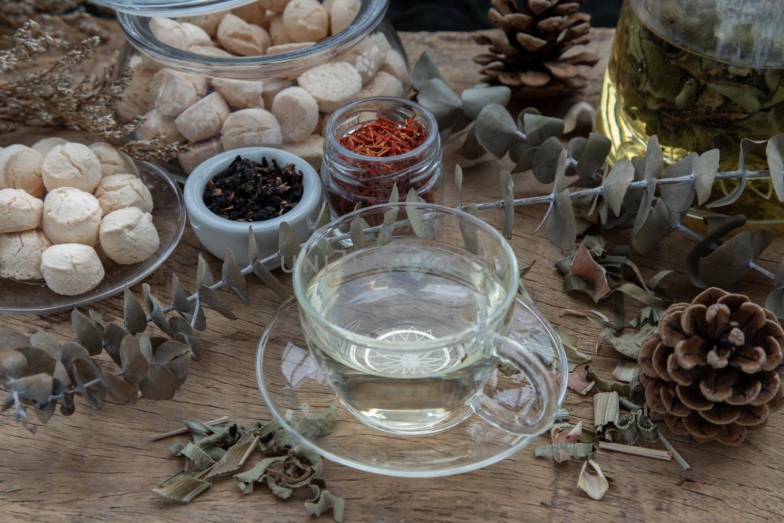 Morning refreshing with herbal tea which is served with Khanom Ping (Thai traditional dessert). The desserts is served on rustic wooden background. Thai style high tea, Selective focus.