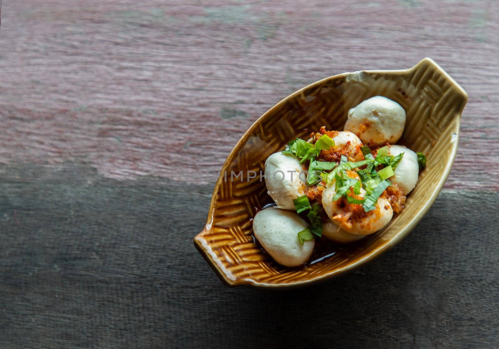 Thai style pork balls seasoning with spicy-sweet dipping sauce in ceramic bowl. It is a delicious appetizer. Copy space, Selective focus.