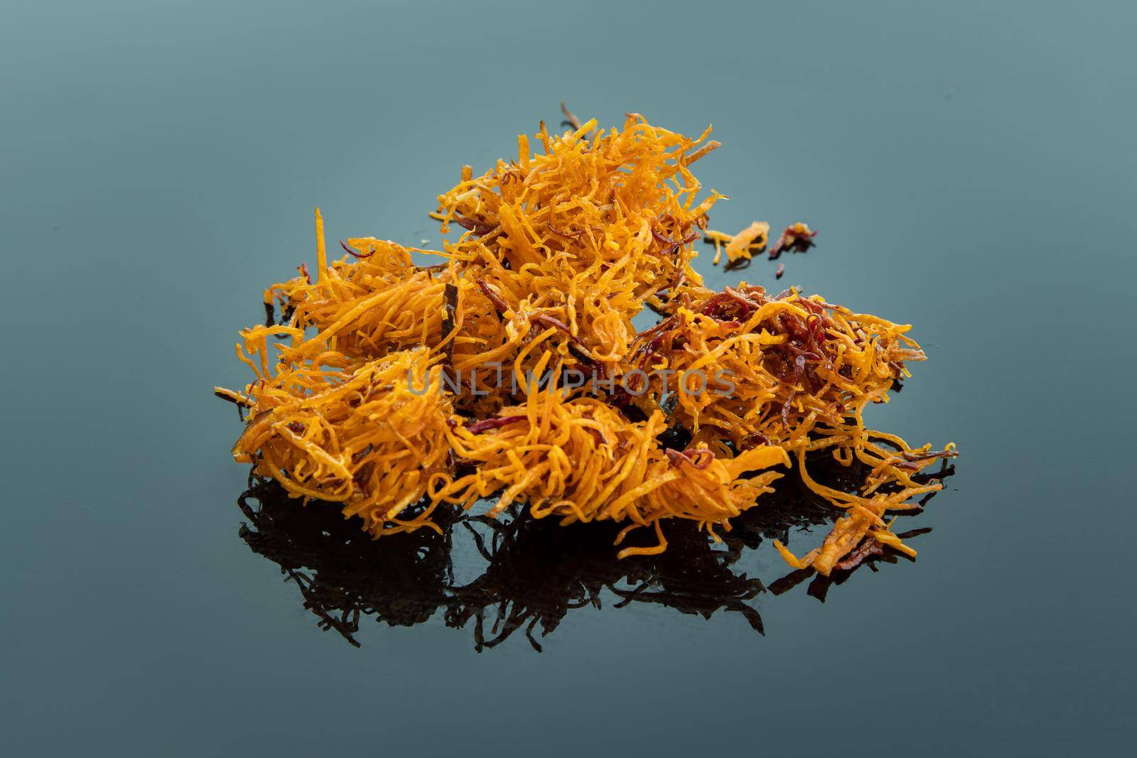 Thai sweets made from shredded sweet potato coated with sugar (Thai sweetmeat made of fried sweet potato) on blue table.  Copy spce, Selective focus.