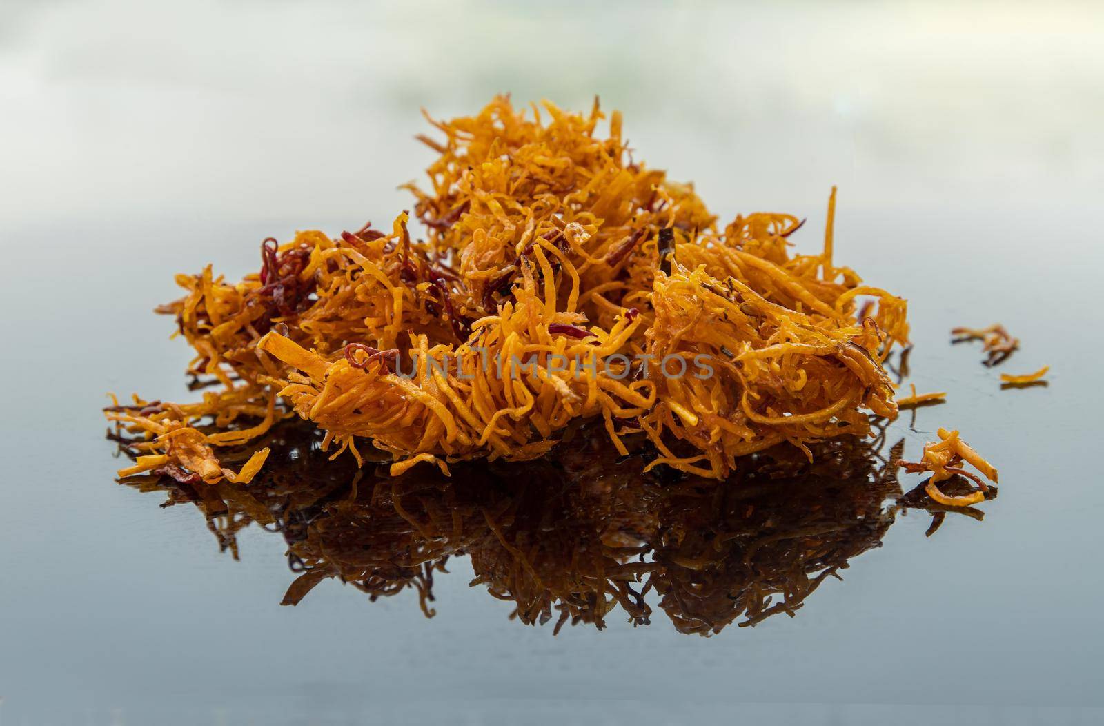 Thai sweets made from shredded sweet potato coated with sugar (Thai sweetmeat made of fried sweet potato) on white table.  Copy spce, Selective focus.