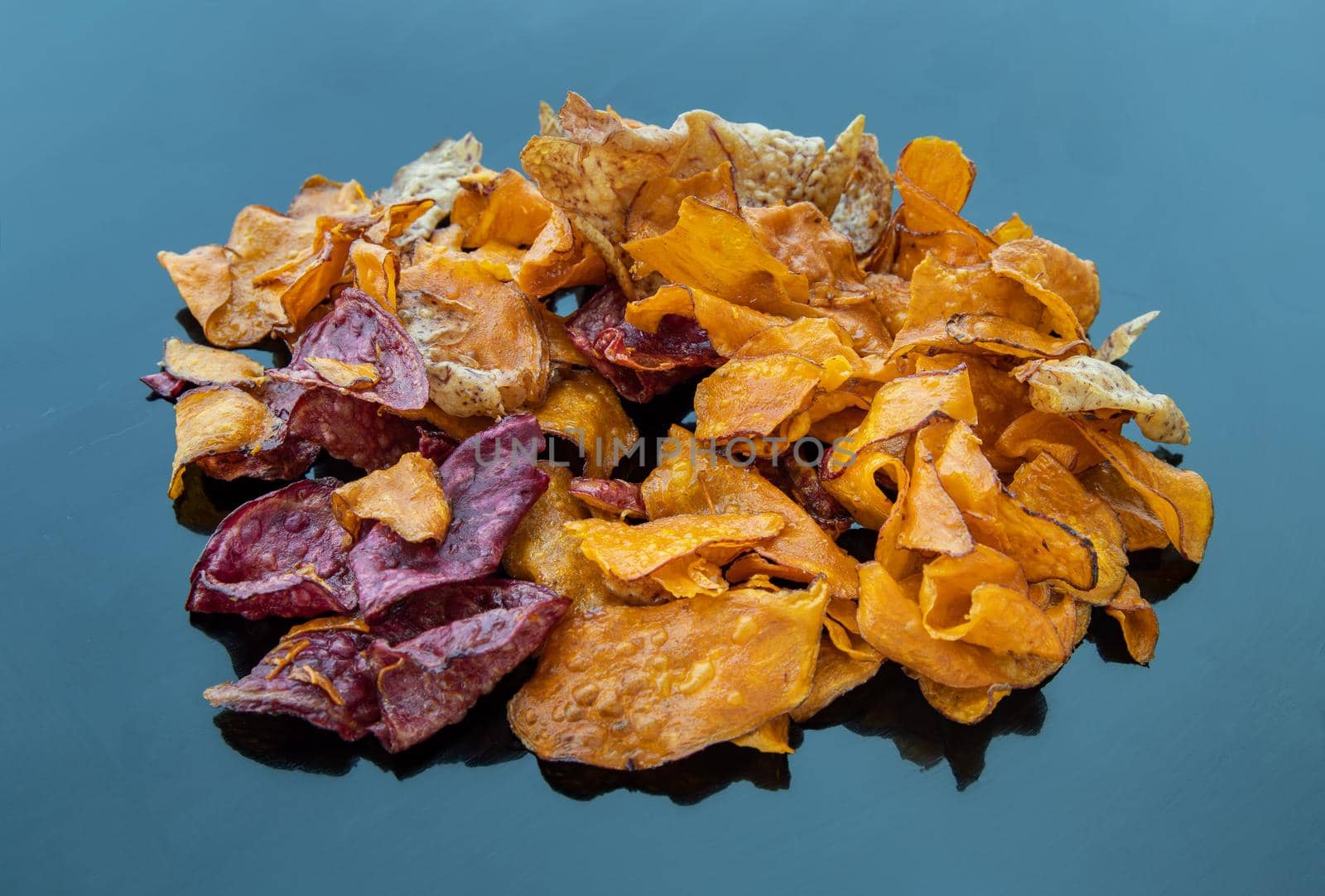 Mixed thai sweets made from sliced sweet potato coated with sugar (Potato chip) on blue table. Copy spce, Selective focus.