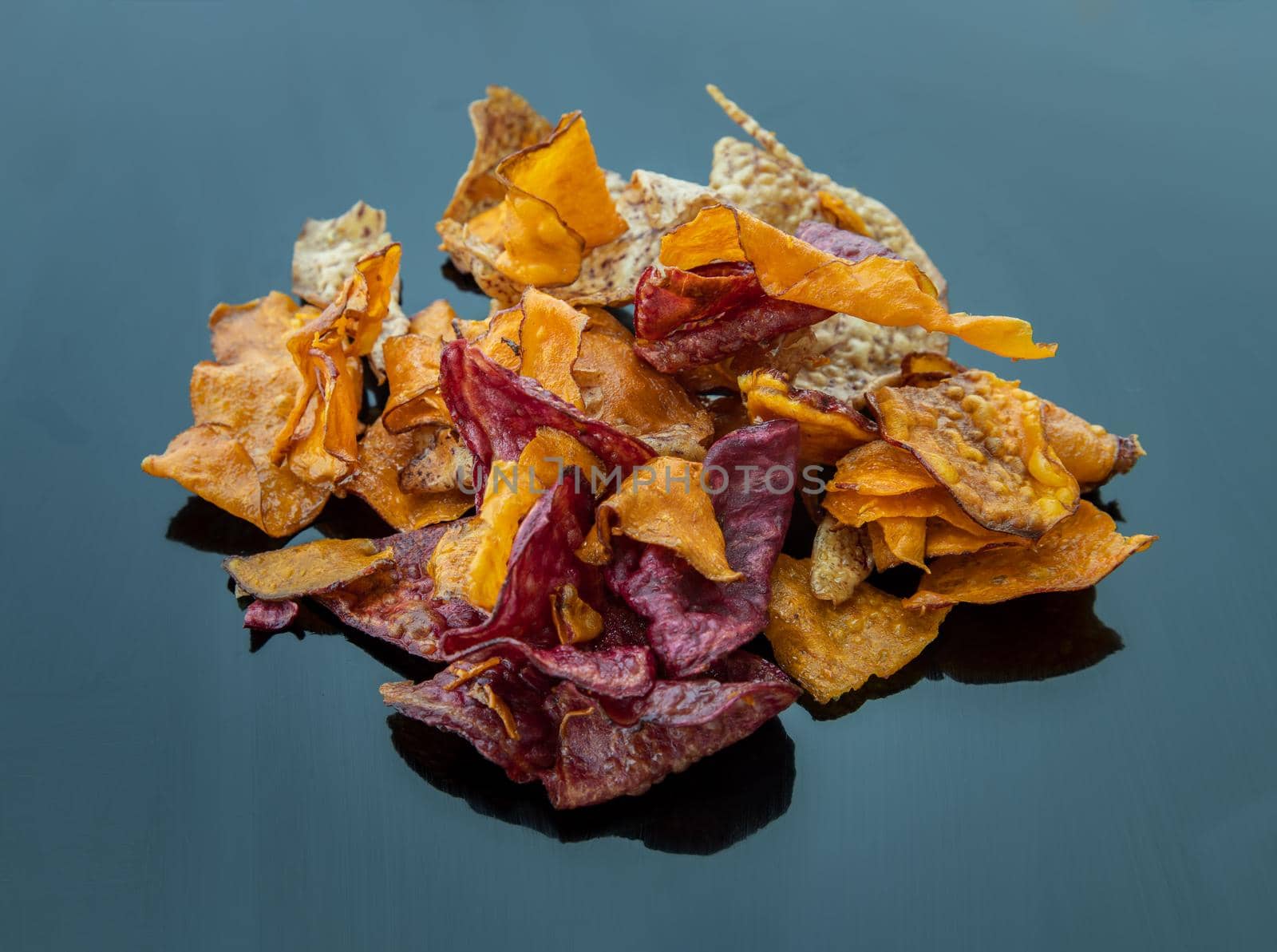 Mixed thai sweets made from sliced sweet potato coated with sugar (Potato chip) on blue table. Copy spce, Selective focus.