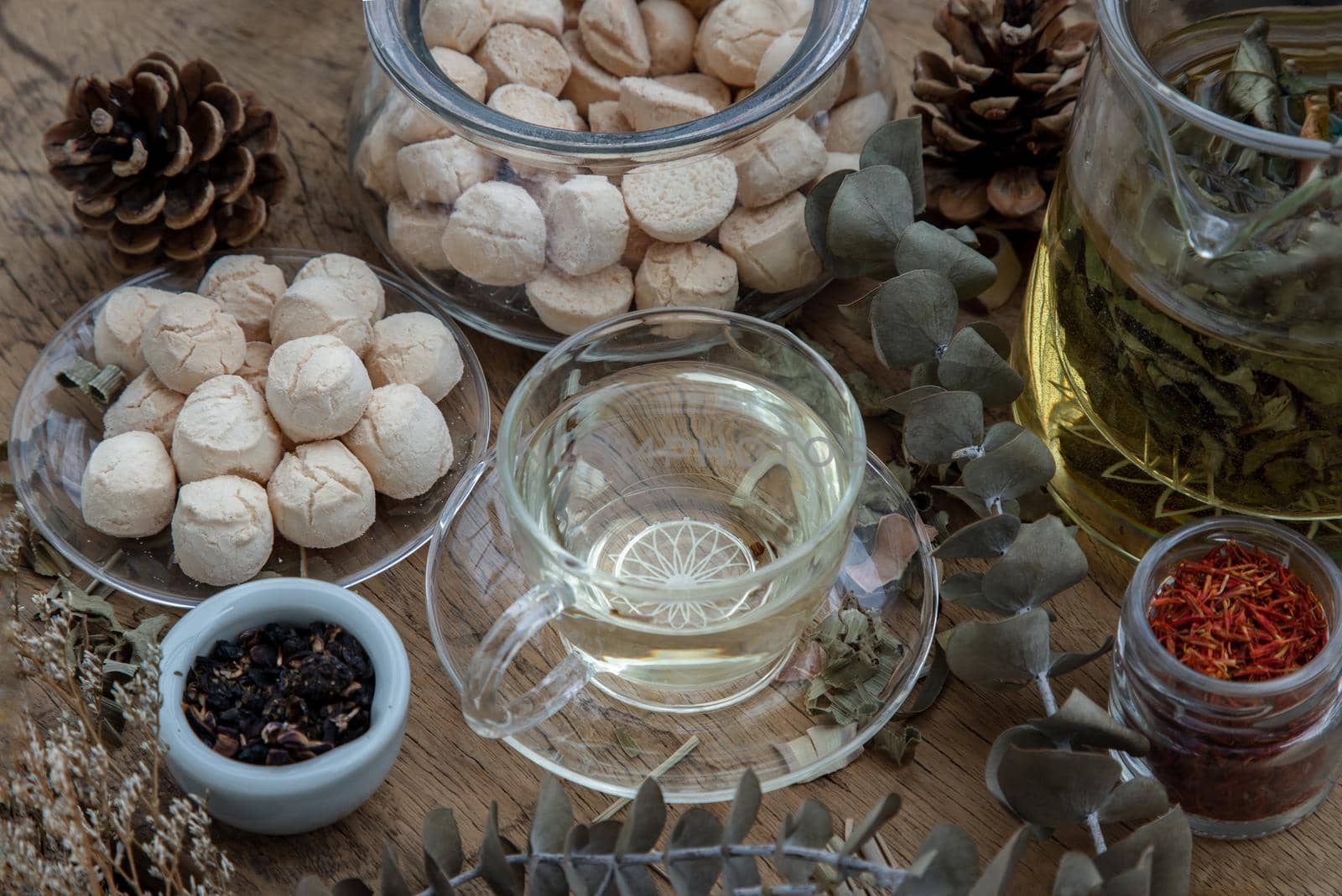 Morning refreshing with herbal tea which is served with Khanom Ping (Thai traditional dessert). The desserts is served on rustic wooden background. Thai style high tea, Selective focus.