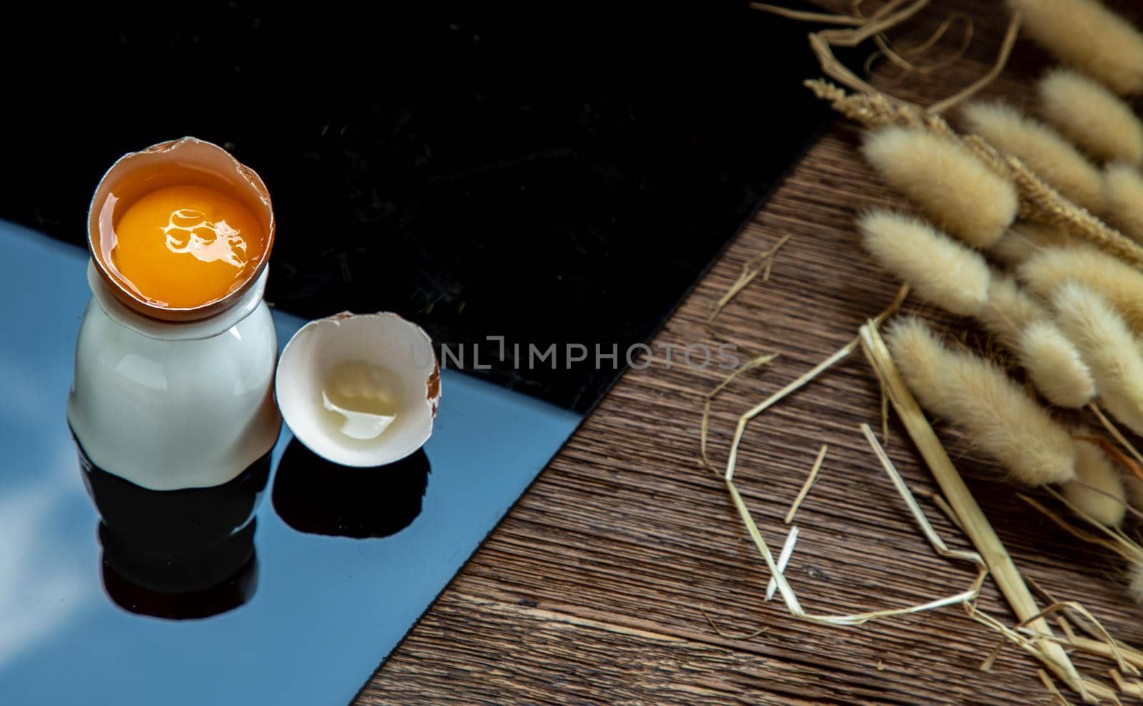 Broken chicken egg and Dried flowers on table. Copy space, Selective focus.