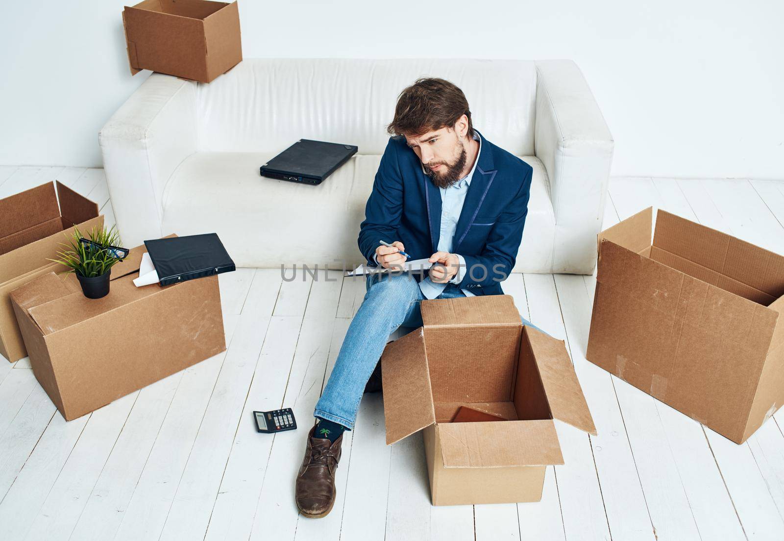 Business man near boxes with things unpacking moving to a new location office official lifestyle. High quality photo