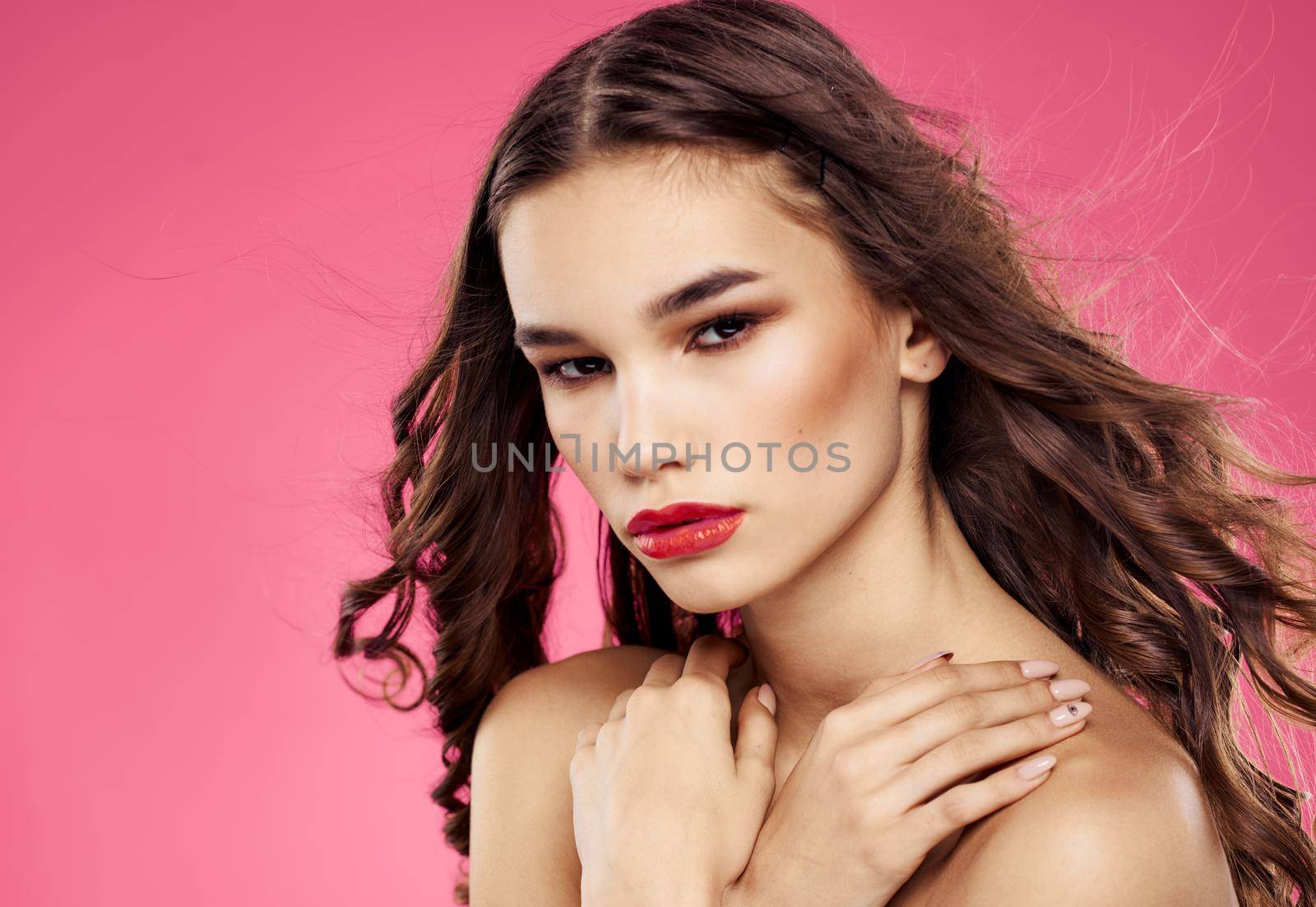 Portrait of an elegant lady with red lips on a pink background with bright makeup. High quality photo