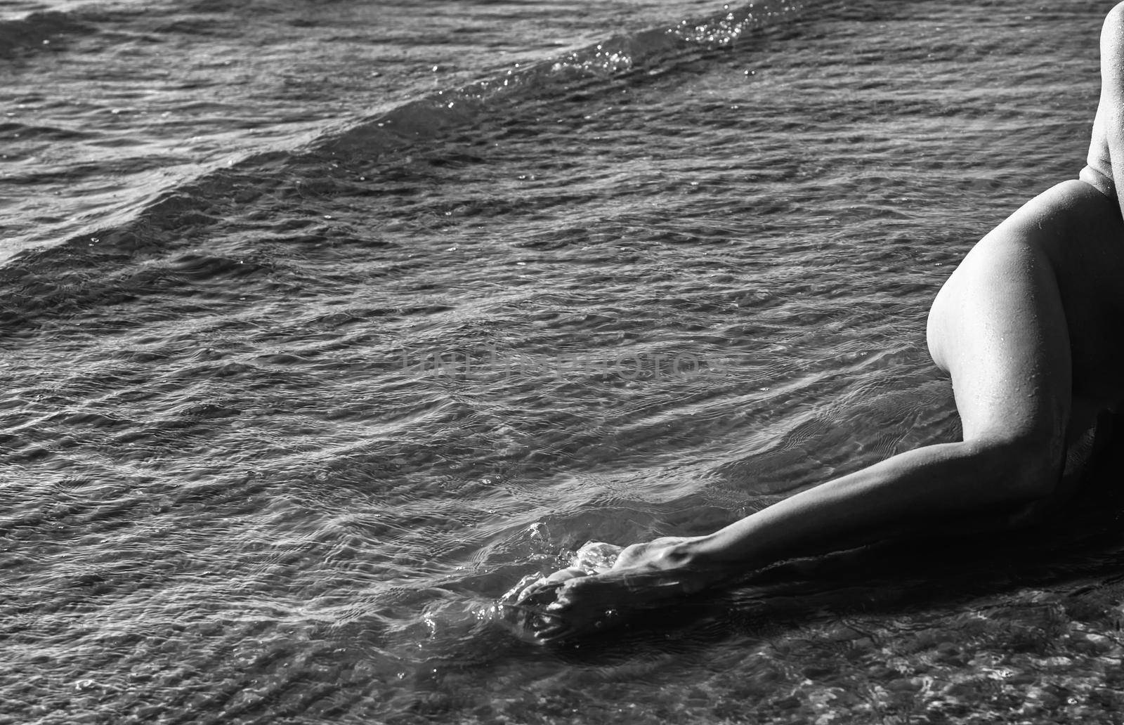 Beautiful girl outdoors enjoying nature. Young naked woman with scarlet dreadlocks enjoys the sea on the coast