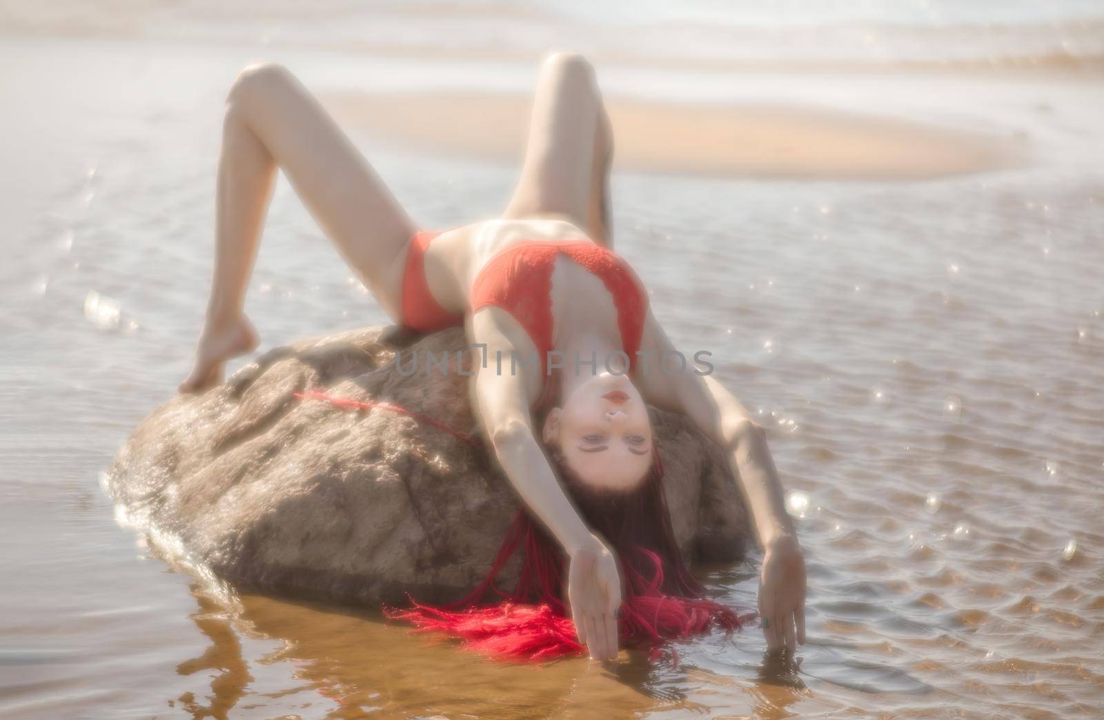 Soft focus blurred image of a beautiful young woman with scarlet dreadlocks and red bathing suit enjoying nature on the beach