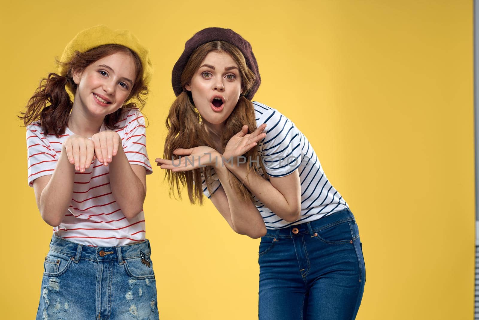 funny mom and daughter fashion clothes studio lifestyle yellow background. High quality photo