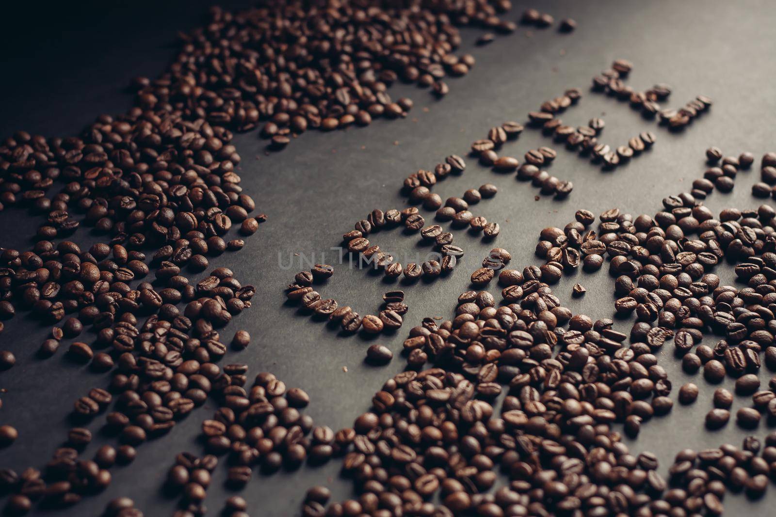 word from coffee beans on gray background close-up drink arabica cappuccino. High quality photo