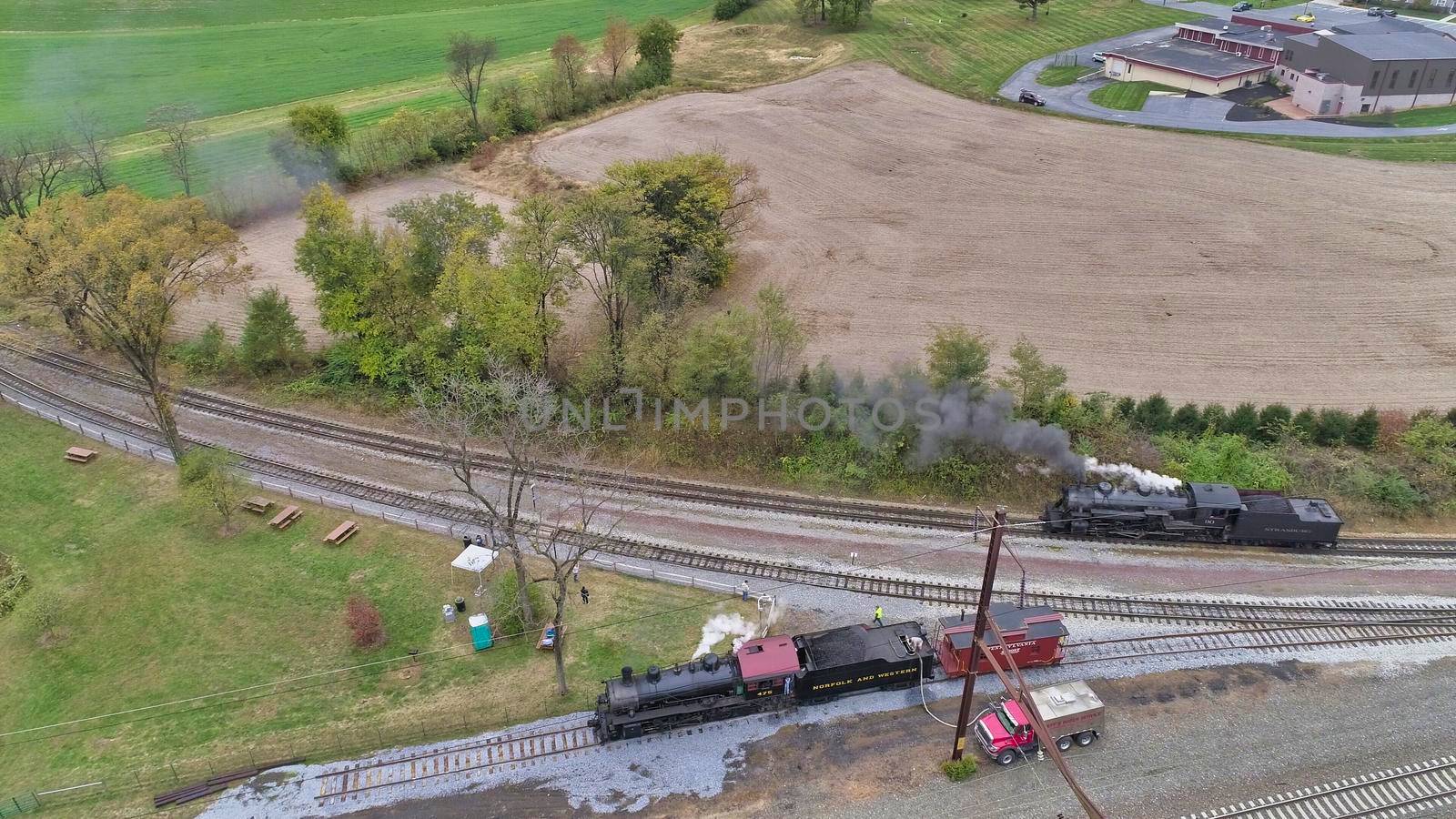 Aerial View of An Antique Restored Steam Locomotive Blowing Smoke and Steam Traveling Thru Farmlands and Countryside on a Sunny Summer Day