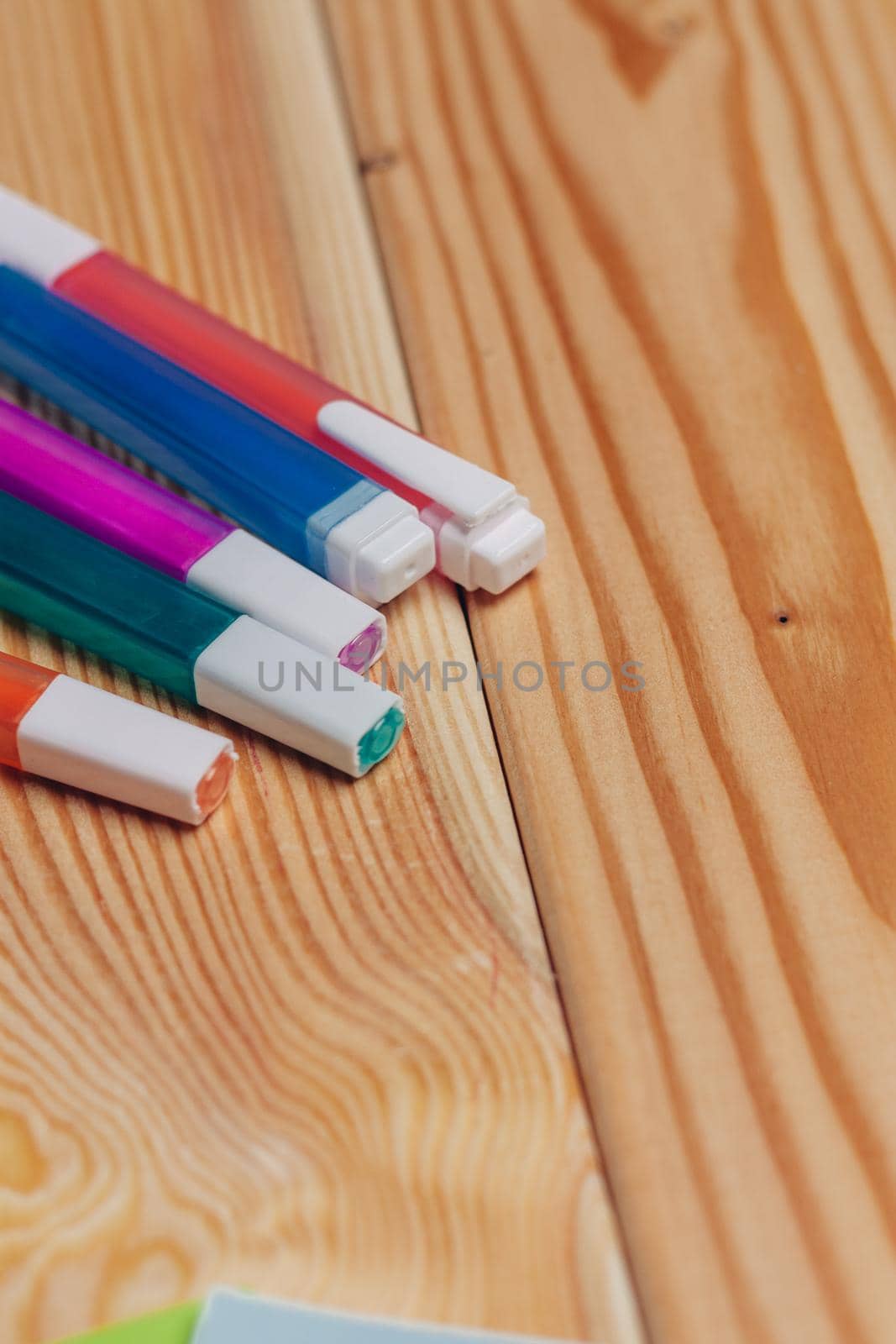 multicolored markers paper office school items wooden table. High quality photo