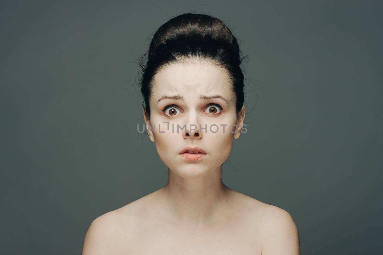 woman with bare shoulders clear skin collected hair emotions. High quality photo
