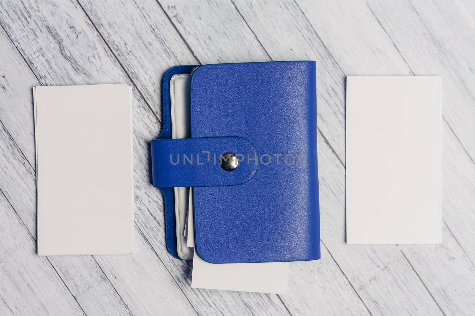 blue business card holder with letterheads on a wooden table top view. High quality photo
