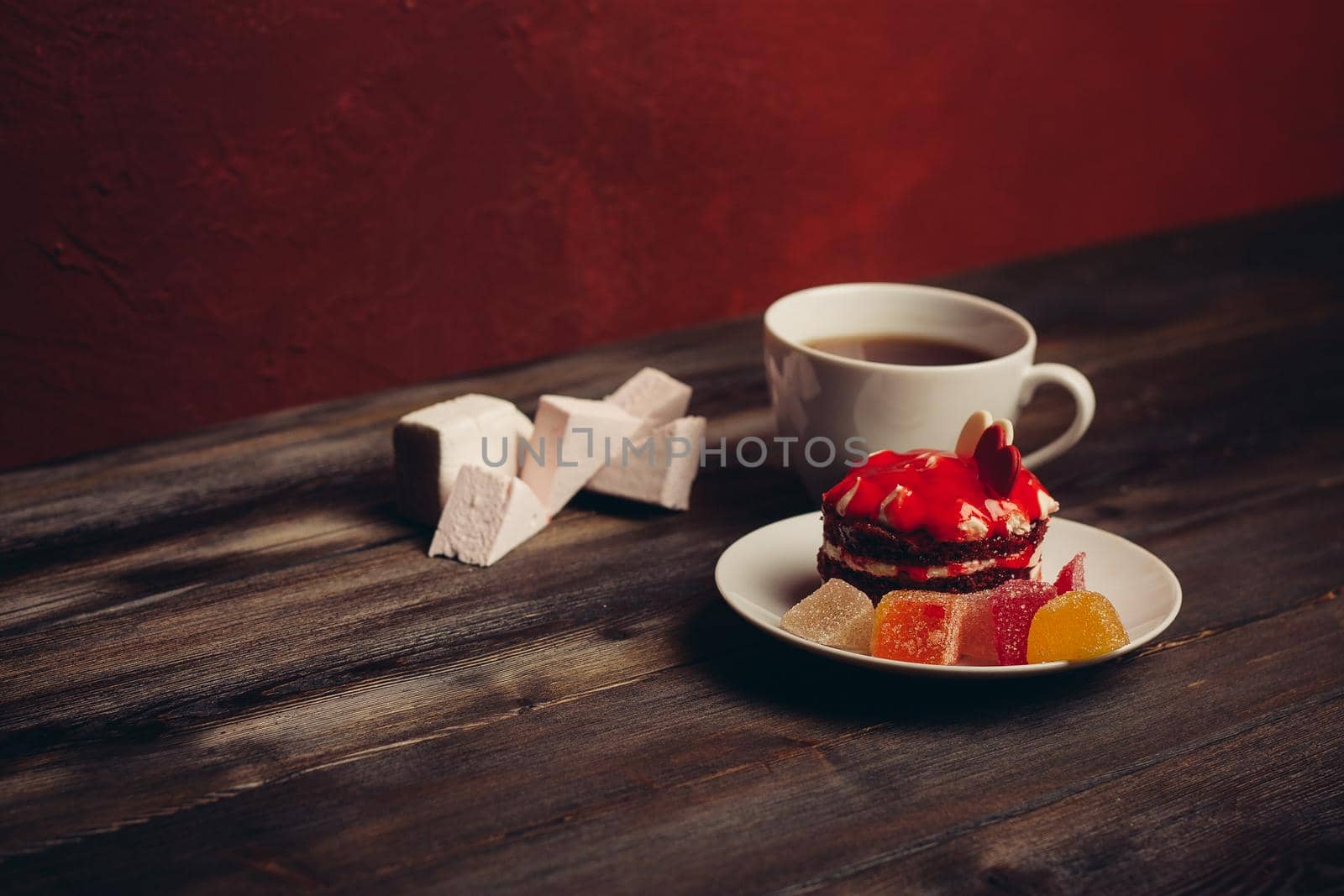 cup of tea red cake on a saucer sweets dessert wooden background. High quality photo