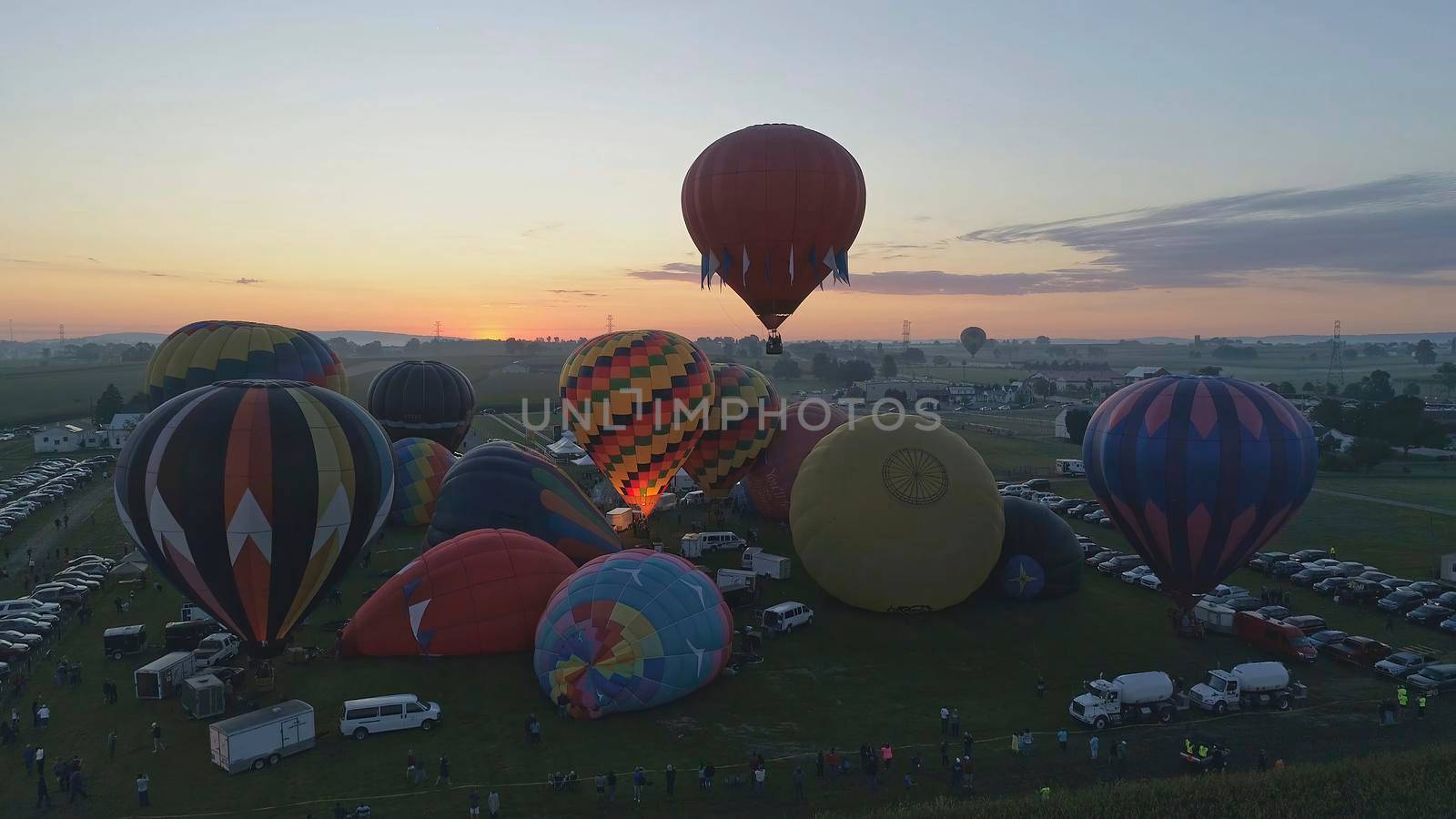 Hot Air Balloons Taking Off at Sunrise at a Hot Air Balloon Festival on a Misty Morning