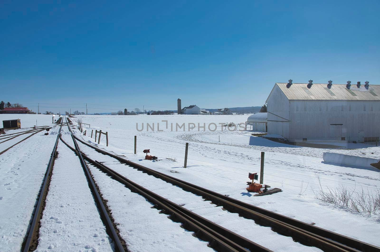 View of Rail Road Tracks Running Thru the Countryside Covered in Snow