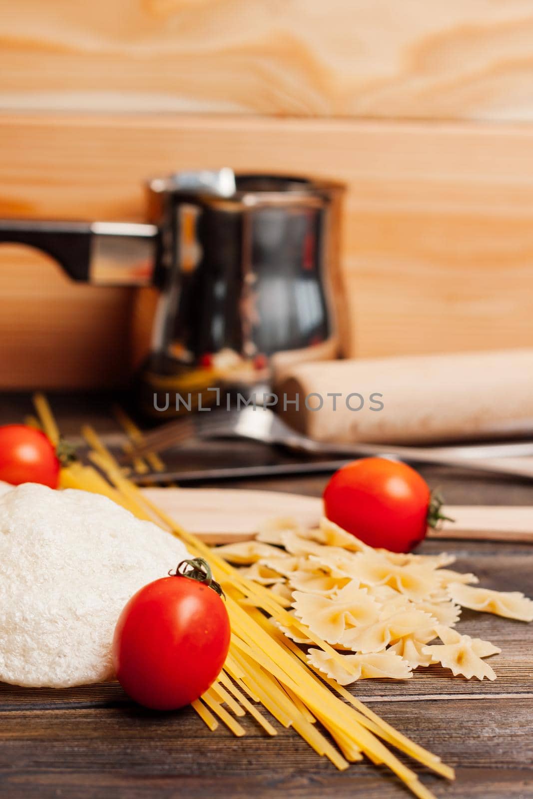 ingredients for italian pasta cherry tomatoes cutting board food preparation. High quality photo