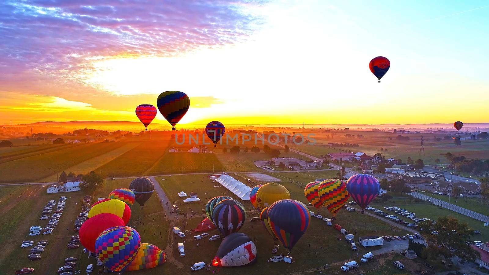 Hot Air Balloons Taking Off at Sunrise at a Hot Air Balloon Festival on a Misty Morning