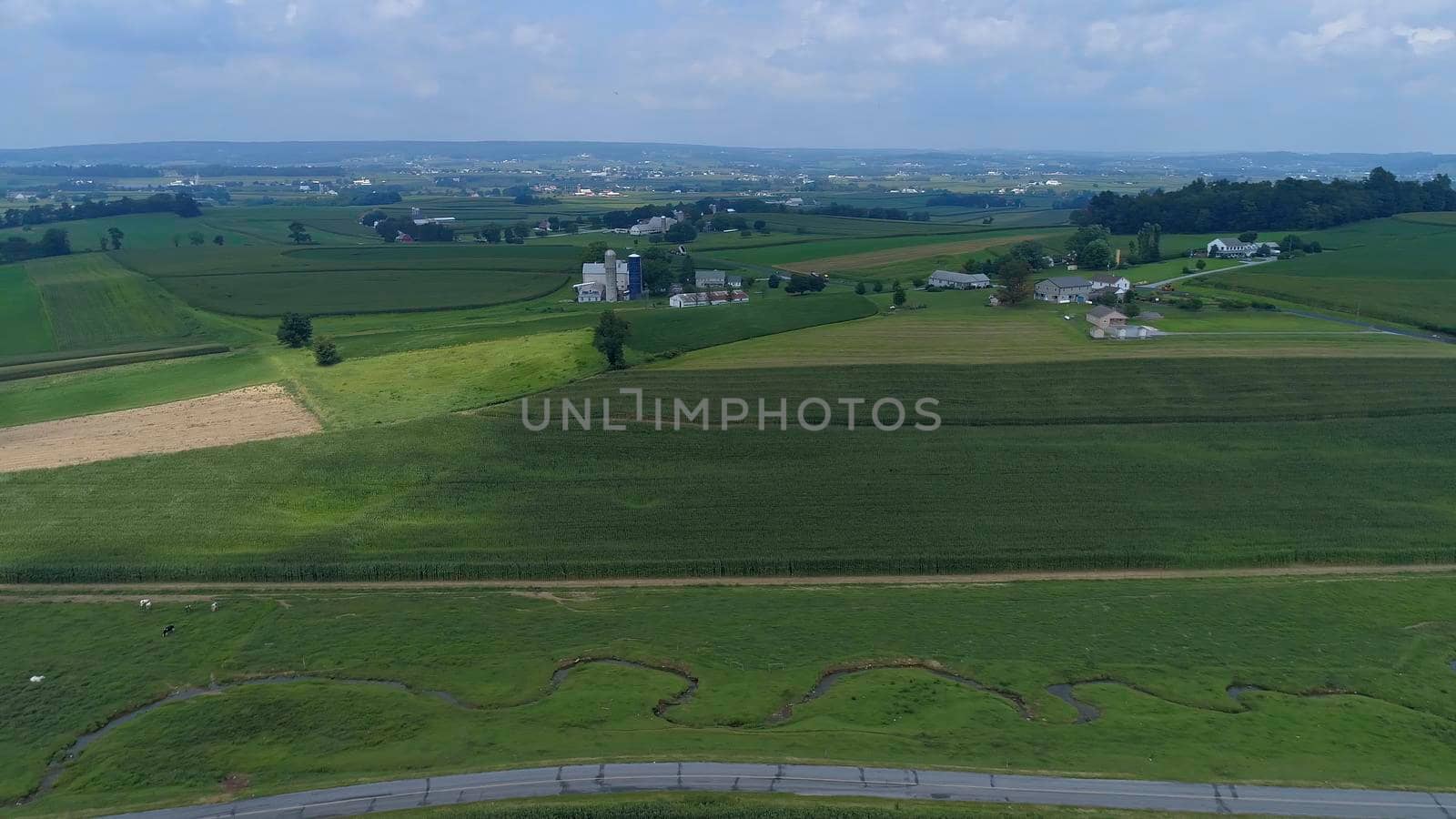 Aerial View of Green Farmlands With Different Crops Growing in the Fields on a Sunny Day