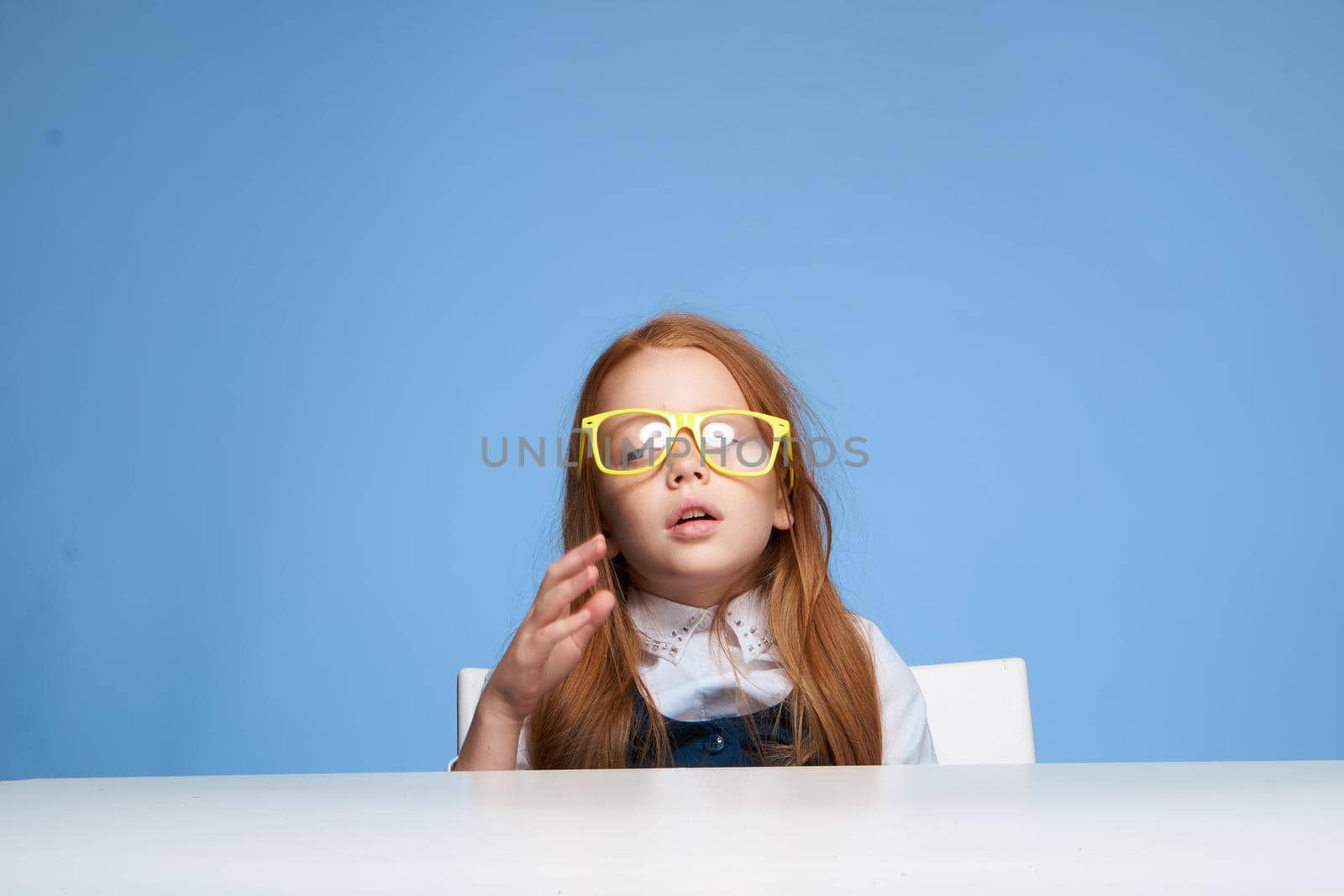 red-haired girl with yellow glasses sitting at the table emotions education by SHOTPRIME