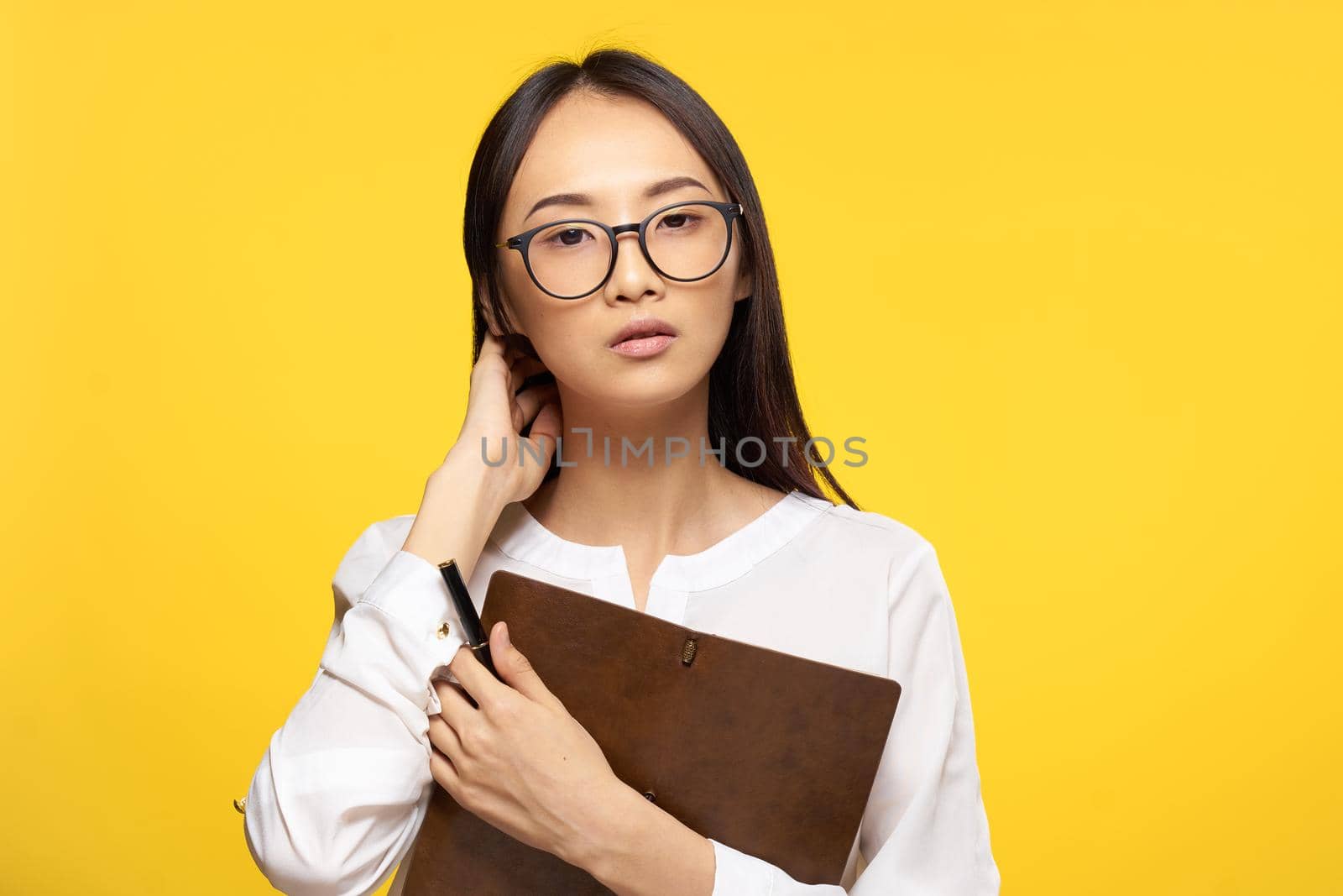 Business woman in glasses with notepad in hands executive secretary yellow background by SHOTPRIME