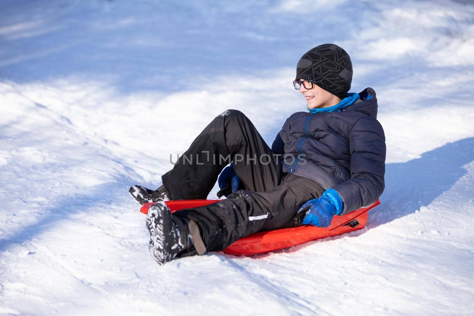 smiling little boy sitting on sled by zhu_zhu